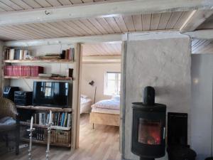 ein Wohnzimmer mit einem Kamin und ein Schlafzimmer in der Unterkunft Sivagerhuset Holiday-Home in Bogense