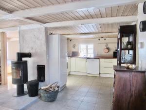 a kitchen with a fireplace and a stove at Sivagerhuset Holiday-Home in Bogense