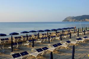 grupa leżaków i parasoli na plaży w obiekcie Casa Vacanze Medit w Alassio