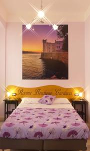 a bedroom with a bed with a painting on the wall at Rooms Boutique Carducci in Trieste