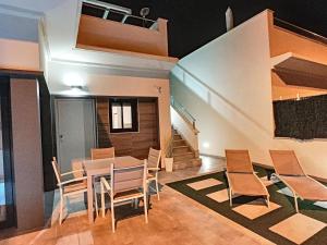 une salle à manger avec une table, des chaises et un escalier dans l'établissement Olivar de Roda Golf - Villa - 1409, à Roda