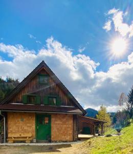 una casa en las montañas con el sol en el cielo en Zirbitz Hütte mit Sauna und Kamin, en Sankt Lambrecht