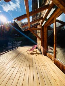 una terraza de madera con el sol en el fondo en Zirbitz Hütte mit Sauna und Kamin, en Sankt Lambrecht