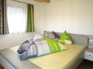 łóżko z kolorowymi poduszkami w pokoju w obiekcie Apartment Nina by Interhome w mieście Uderns +17 zdjęć