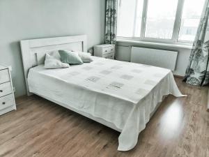 ein Schlafzimmer mit einem großen weißen Bett mit weißer Bettwäsche in der Unterkunft Suur-Sepa apartment near city centre and beach in Pärnu