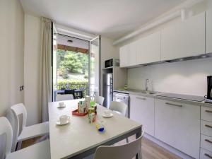 a kitchen with white cabinets and a table and chairs at Apartment Fon 105 by Interhome in Fondotoce +15 photos