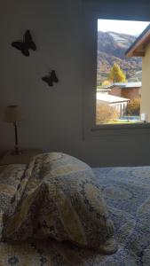 1 dormitorio con 1 cama y una ventana con mariposas en la pared en Duplex en la Base del Cerro en San Carlos de Bariloche