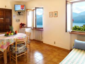 un soggiorno con tavolo, sedie e finestre di Apartment Belvedere-1 by Interhome a Malcesine
