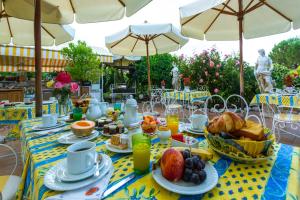 サン・ポール・ド・ヴァンスにあるル アモーの傘付きテーブルの上に朝食用の食材を並べたテーブル