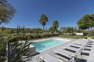 una piscina con tumbonas y una piscina en Villa Isabelle - Loule, en Loulé