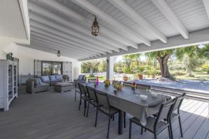 a dining room with a table and chairs on a deck at Villa Isabelle - Loule in Loulé