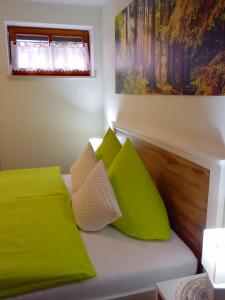 a bedroom with green pillows on a white couch at WALDFEE in Bodenmais