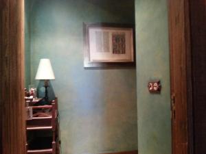 a room with a green wall with a lamp and a light at Hotel Rural Peña Del Alba in Arroyomolinos de la Vera