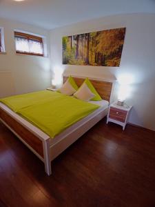 a bedroom with a large bed with a green blanket at WALDFEE in Bodenmais