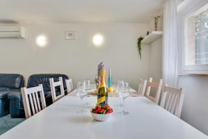 a dining room table with a bottle of wine and glasses at InVilla Seristori, a 50 m dal mare in San Vincenzo