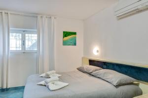 a white bedroom with a large bed with white pillows at InVilla Seristori, a 50 m dal mare in San Vincenzo