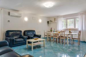een woonkamer met een bank en een tafel en stoelen bij InVilla Seristori, a 50 m dal mare in San Vincenzo