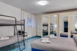 a bedroom with two bunk beds and a mirror at InVilla Seristori, a 50 m dal mare in San Vincenzo +39 photos