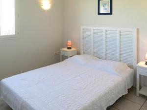 a bedroom with a white bed and two night stands at Holiday Home Résidence Plage Océane - BPL341 by Interhome in Biscarrosse-Plage