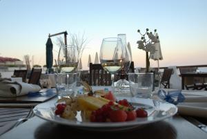a plate of food on a table with wine glasses at Hotel Cavalluccio Marino in Santa Marinella