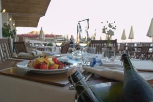 a table with a bottle of champagne and a plate of fruit at Hotel Cavalluccio Marino in Santa Marinella