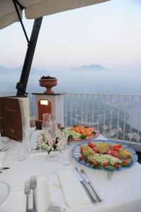 a white table with two plates of food on it at Hotel Villa Fraulo in Ravello
