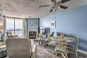 Luxury Myrtle Beach Condo Oceanfront with Hot Tub! في ميرتل بيتش: غرفة معيشة مع طاولة وكراسي وأريكة