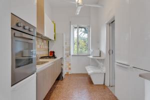 Una cocina con gabinetes blancos y una ventana. en InVilla Seristori, a 50 m dal mare, en San Vincenzo 39 fotos más
