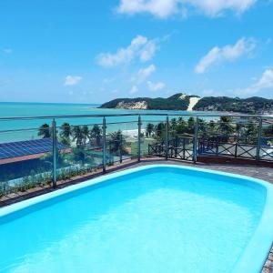 a swimming pool with a view of the ocean at Residence Victoria Brasil in Natal