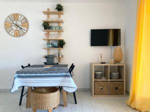 una sala da pranzo con un tavolo e una tv di l'escale a Cogolin