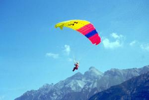 een persoon die met een parachute in de lucht vliegt bij Aparthotel Krösbacher in Fulpmes