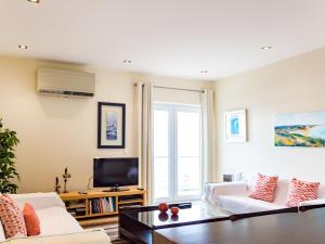 - un salon avec deux canapés blancs et une télévision dans l'établissement Apartment Panoramico - FDA115 by Interhome, à Foz do Arelho