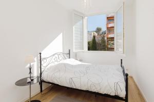 1 dormitorio con cama y ventana en SuperCannes Center - Parking - Spacieux 70 Metres - Clim - Wifi en Cannes