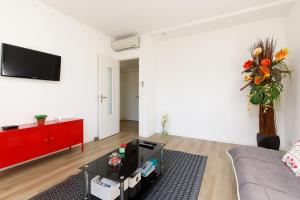 a living room with a couch and a tv on a wall at SuperCannes Center - Parking - Spacieux 70 Metres - Clim - Wifi in Cannes