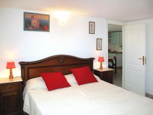 a bedroom with a bed with two red pillows at Apartment Mandarino by Interhome in Montignoso