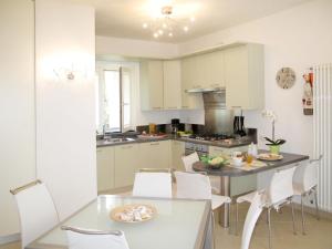 a kitchen with white cabinets and a table and chairs at Apartment Mia by Interhome in Montignoso