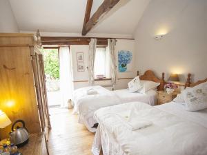 1 dormitorio con 2 camas y ventana en Beeches Farmhouse Country Cottages & Rooms, en Bradford on Avon