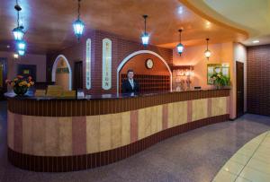 a woman standing at a counter in a hotel lobby at Optima Odesa in Odesa