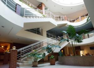 un escalier en colimaçon dans un bâtiment orné de plantes dans l'établissement Optima Odesa, à Odessa