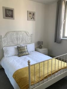 a bedroom with a white bed with a metal headboard at Apex Variety Gate Apartment in Glasgow