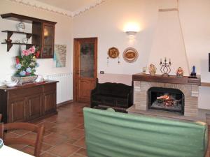 ein Wohnzimmer mit einem Kamin und einem Stuhl in der Unterkunft Holiday Home Villetta degli Orti by Interhome in Montemagno
