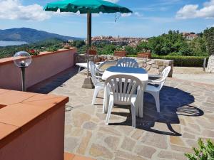 uma mesa e cadeiras num pátio com um guarda-sol em Apartment Abete by Interhome em Capoliveri