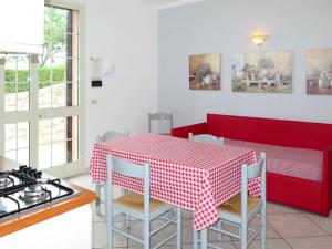 uma cozinha com uma mesa e cadeiras vermelhas e um fogão em Apartment Abete by Interhome em Capoliveri