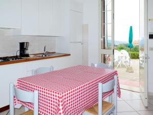 una cucina con tavolo e sedie a scacchi rossi e bianchi di Apartment Abete by Interhome a Capoliveri