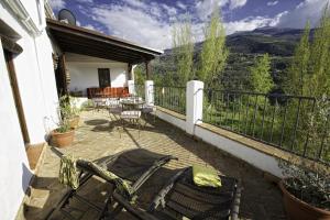 d'une terrasse avec des chaises et une table sur un balcon. dans l'établissement Casa Rural Arroyo de la Greda, à Güéjar-Sierra