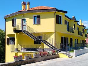 ein gelbes Haus mit Treppe davor in der Unterkunft Apartment Faggio - SBO101 by Interhome in Savona