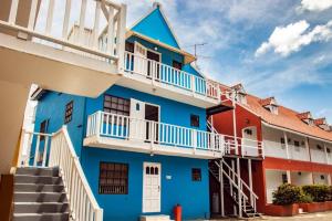 a blue building with white balconies and stairs at CityLife Apartments in Historic Willemstad - 2 bedroom apartment - K in Willemstad