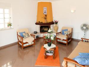 a living room with three chairs and a fireplace at Holiday Home Da Bela Vista - PAD110 by Interhome in Paderne