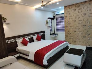 um quarto com uma cama grande e almofadas vermelhas em Pagadala Grand Residency em Bāpatla