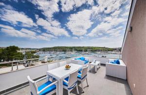 a balcony with a table and chairs and a view of a harbor at Ribarska Koliba Resort in Pula